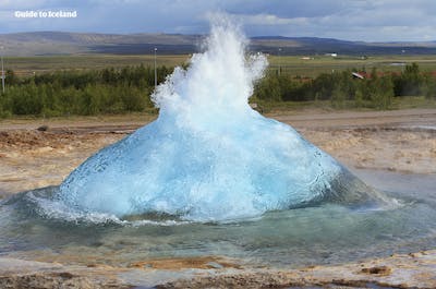 Gejzer Strokkur wybucha w obszarze geotermalnym Geysir na trasie zwiedzania Złotego Kręgu.