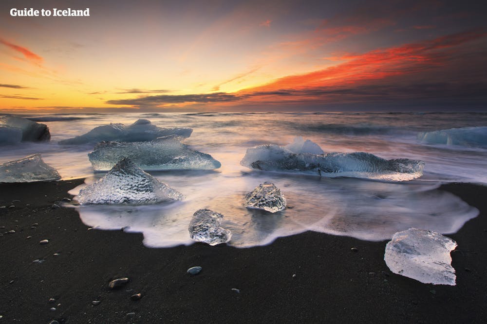 백야의 태양에 다이아몬드 해변을 장식한 얼음조각이 빛의 공연장으로 변신합니다.