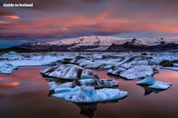 Голубые айсберги откалываются от отдного из ледниковых языков в парке Ватнайёкютль, и дрейфуют по ледниковой лагуне Йокульсарлон нв юго-востоке Исландии.