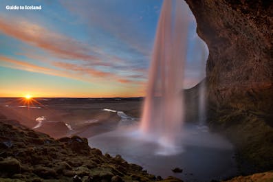 The stunning Seljalandsfoss waterfall bathed in the midnight sun.