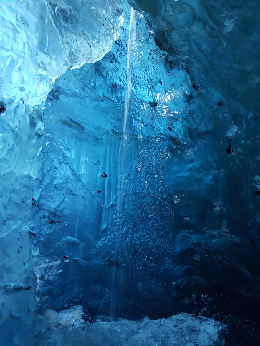 Kleiner Wasserfall in der blauen Eishöhle auf dem Vatnajökull in Island.