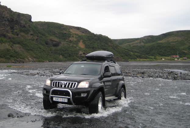 A 4x4 drives through a small lake in the Thorsmork Valley.