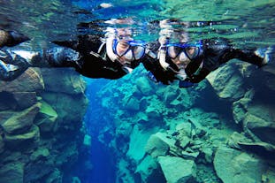 To blide mennesker på snorkletur i Silfra-sprekken