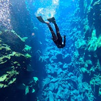 Een deelnemer gebruikt zwemvliezen om verder in Silfra te duiken