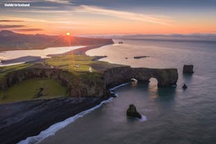 En solnedgang over Dyrholaey-klipperne på Islands sydkyst