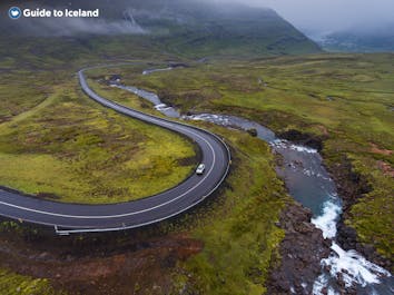 A birdseye view of a winding road and its surrounding landscape in the East of Iceland.