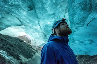 Een ijsspeleoloog bewondert de kleuren van de gletsjer van Skaftafell.