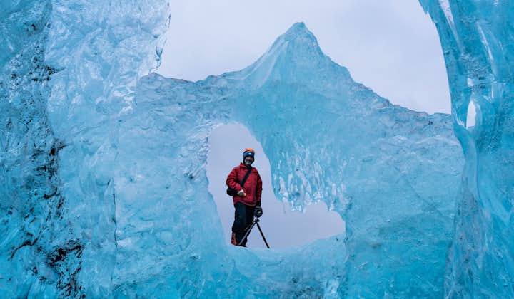 An image of a traveller shot through a gap in some ice.