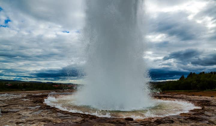 The Strokkur geyser erupts and produces an amazing display of water at the Geysir geothermal area.
