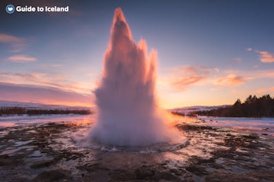 The Strokkur geyser in the Haukadalur valley erupting as the sun starts to set.