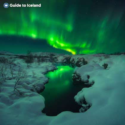 แสงเหนือในประเทศไอซ์แลนด์ส่องสว่างเหนือทิวทัศน์ของหิมะ