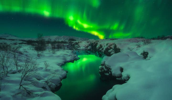 Die Nordlichter erhellen eine Winterlandschaft in Island