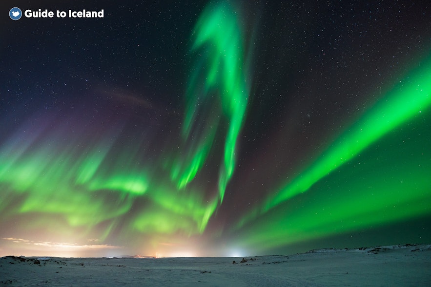 Zorza polarna rozświetla niebo na Islandii w miesiącach zimowych.