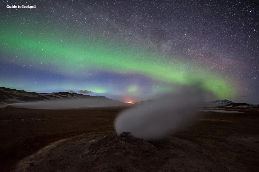 The Northern Lights shine brightly over a geothermal area in Iceland