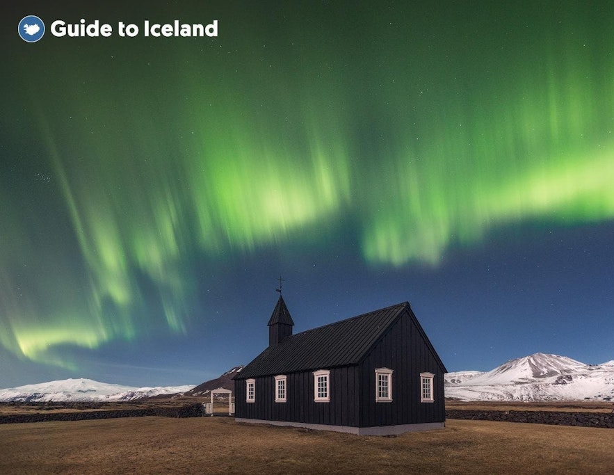The Northern Lights light up the sky above the black church at Budir