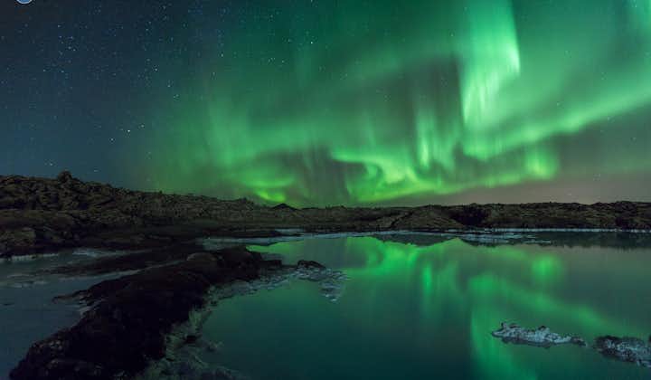 L'aurora boreale sopra uno specchio d'acqua nella penisola di Reykjanes, in Islanda.