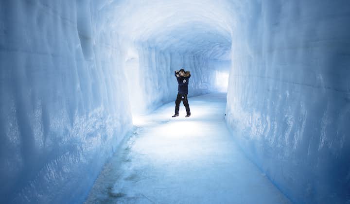 The long tunnel under the glacier with a visitor taking a picture.