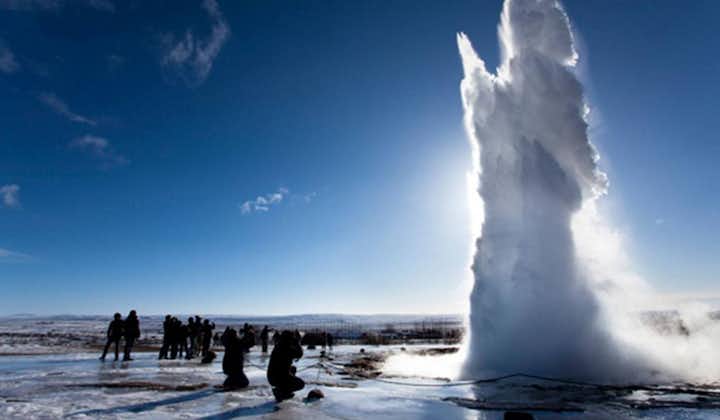 A geyser erupts against a clear sky in the south of Iceland.