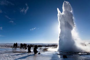 A geyser erupts against a clear sky in the south of Iceland.