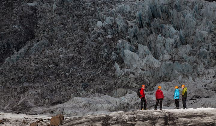 Three people talking on a glacier hike in the south of Iceland.