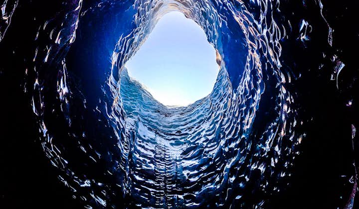 The view of the blue sky from inside an ice cave.
