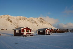 Outside view of the quaint red Moar Cottage #2 with the surroundings blanketed in snow.