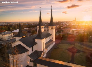 Vue du centre-ville de Reykjavik sur les toits, avec le soleil couchant en arrière-plan.