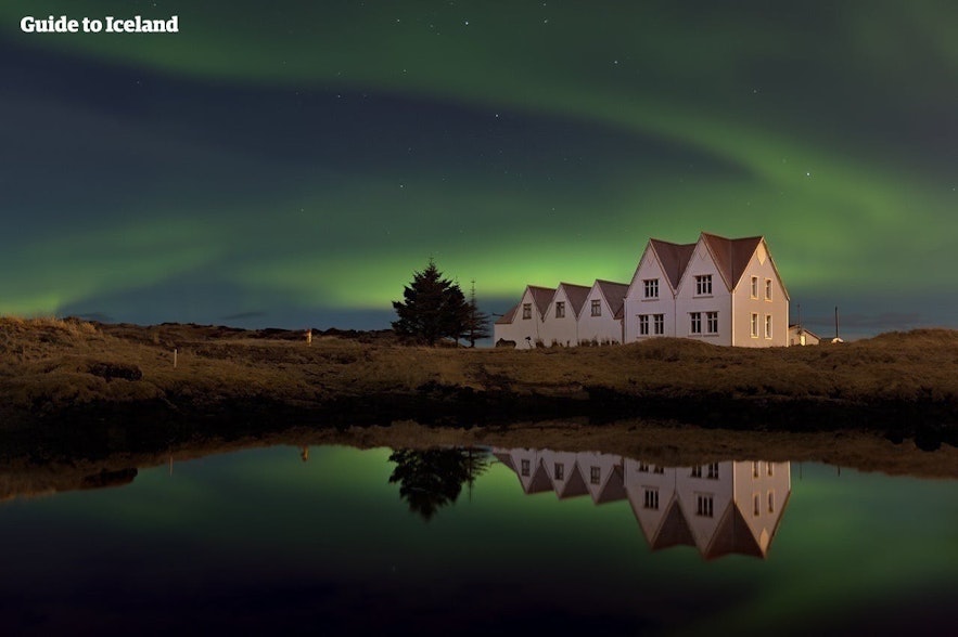 아이슬란드 레이캬비크 지역의 두 집 위로 보이는 오로라