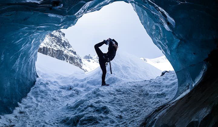 A woman doing a yoga pose within an ice cave in Iceland