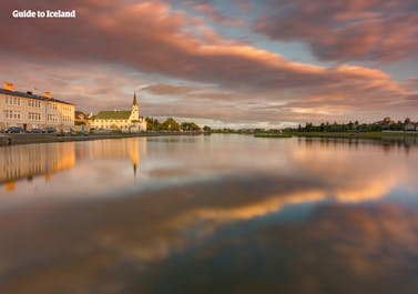 The city reflected in the waters of Tjörnin Pond in downtown Reykjavik.