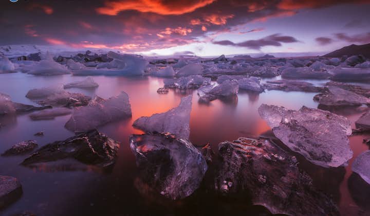 Een roze zonsondergang boven de Jokulsarlon-gletsjerlagune aan de zuidkust van IJsland.