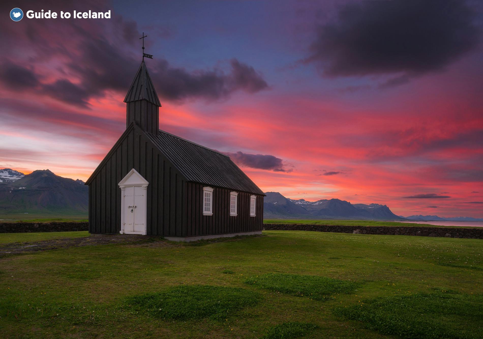 De zwarte kerk van Budir op het schiereiland Snaefellsnes in West-IJsland, gefotografeerd bij zonsondergang.
