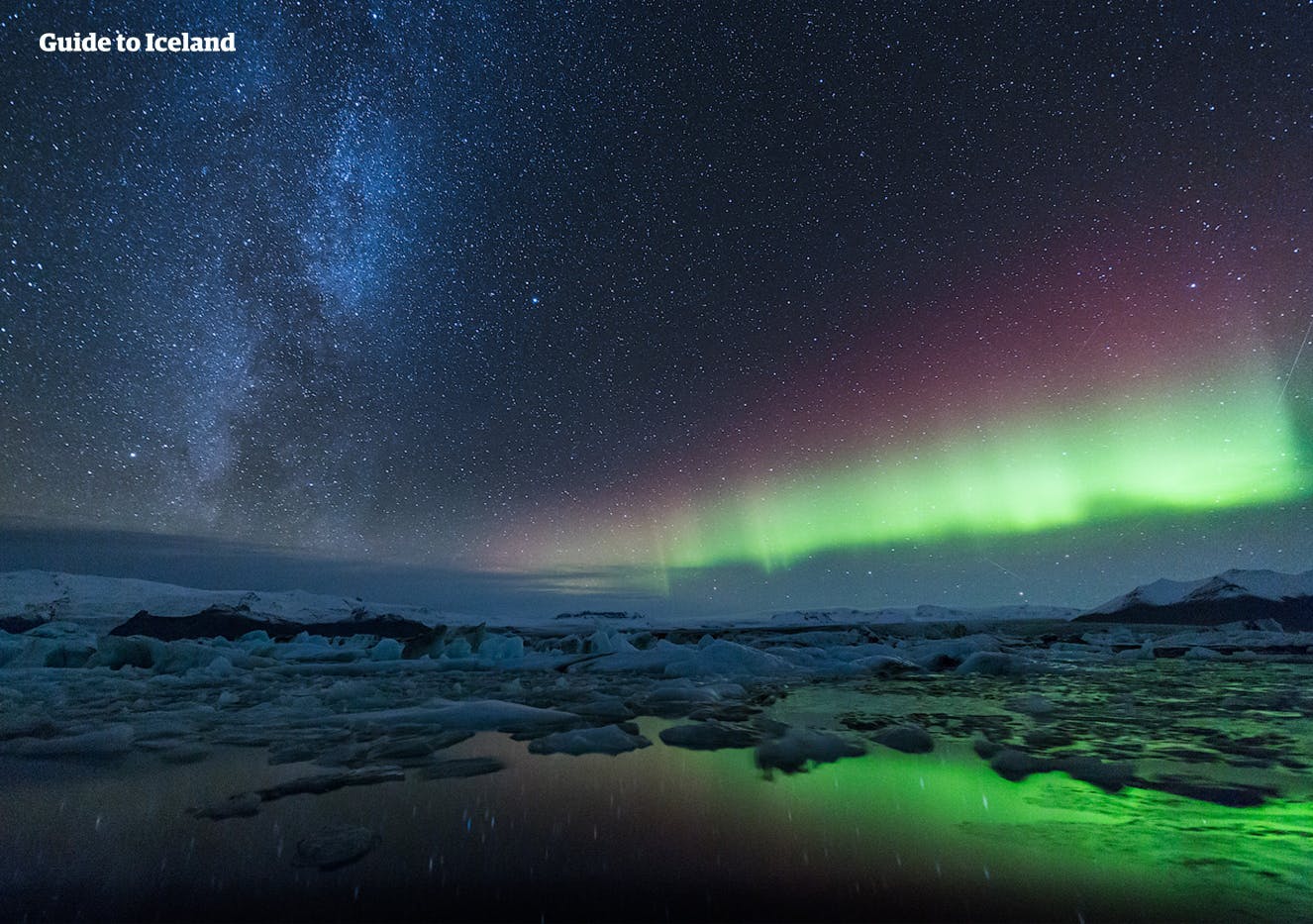 Los colores verde, rosa y morado de la aurora boreal mientras bailan sobre la laguna glaciar Jökulsárlón