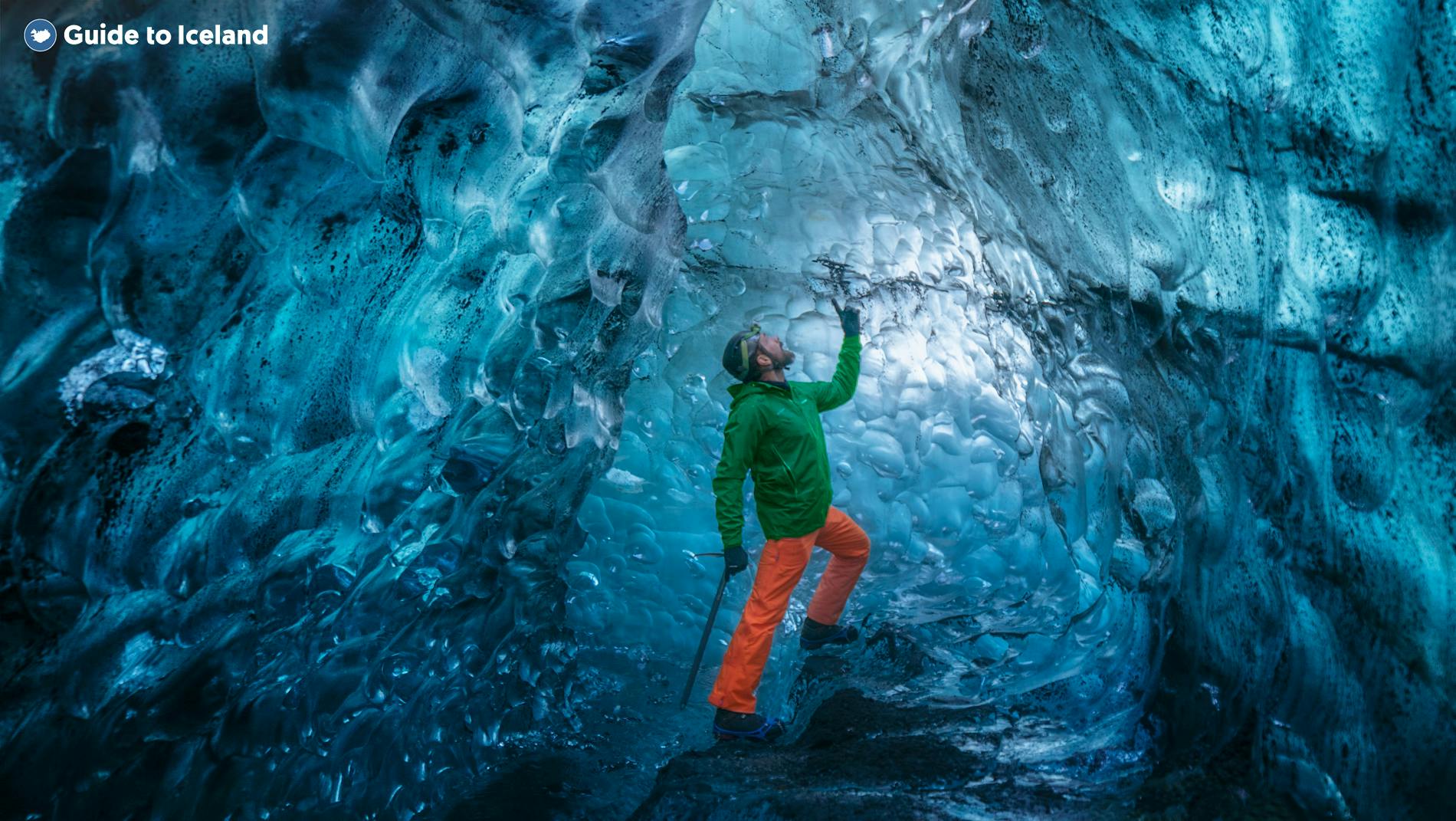Gość podziwiający kolory wnętrza jaskini lodowcowej na Islandii.