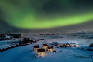 Hotel Laekur is a lovely set of cabins and rooms, pictured under the aurora borealis.