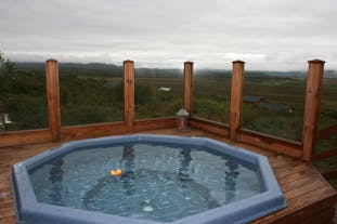 Z tarasu z wanną z hydromasażem w domu wakacyjnym Solbakki Holiday Home roztacza się widok na islandzką wieś.