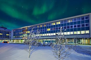 Icelandair Hotel Reykjavik Natura, pictured in winter beneath the aurora borealis.