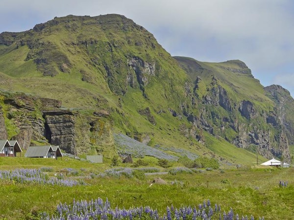 Mountains surround the Vík Cottages.