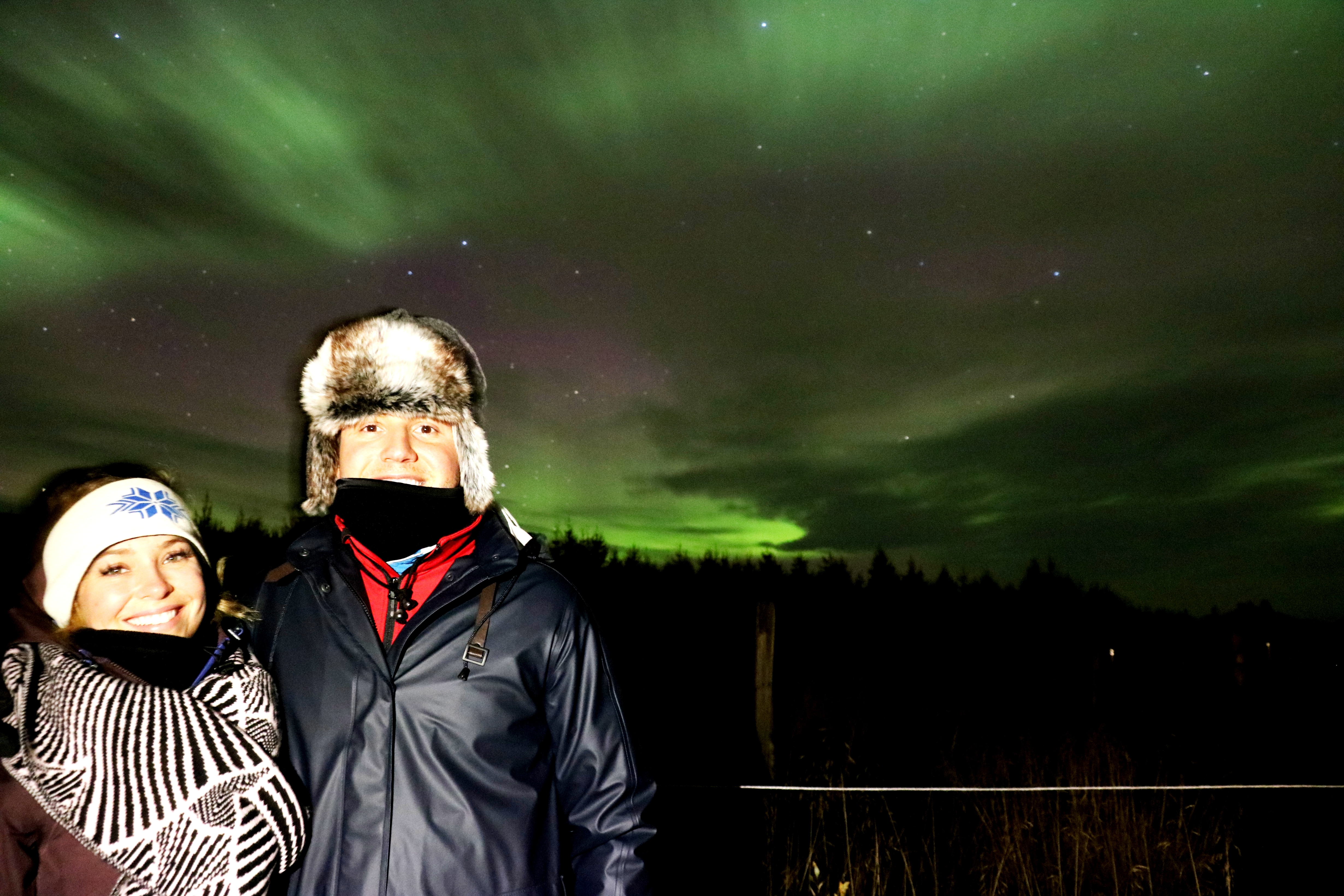 A couple enjoy the Northern Lights in North Iceland.