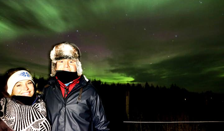 A couple enjoy the Northern Lights in North Iceland.