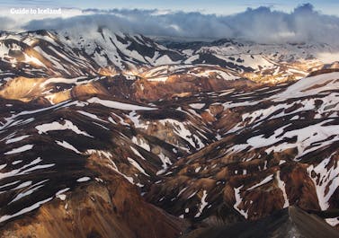 An aerial view of snow-coated mountains in the Highlands of Iceland.