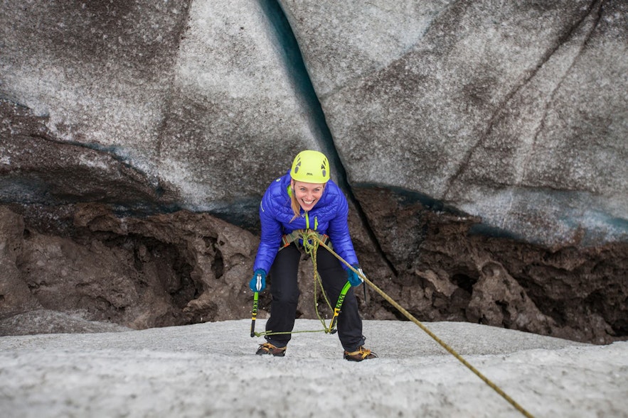 Une femme en train de faire de l'escalade sur glace à Sólheimajokull