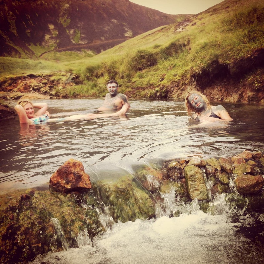 Podróżni korzystający z gorących źródeł rzeki w Reykjadalur