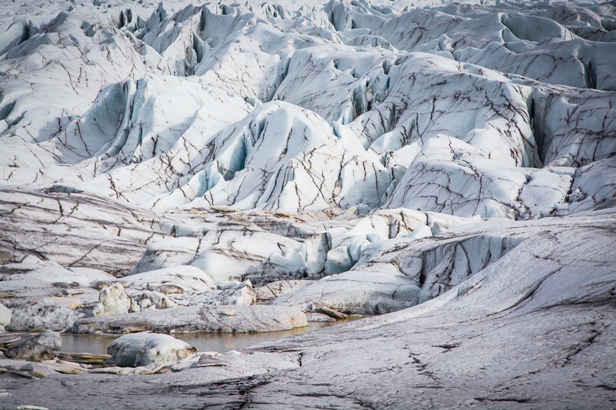 Die Bewegung von Gletschern führt zu Zugbelastungen an ihren spröden oberen Teilen, wodurch sie brechen und Gletscherspalten entstehen.