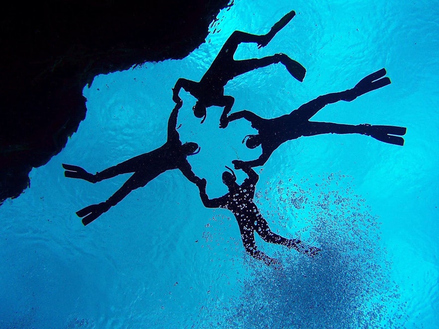 A scuba diver descends into the depths of Silfra Fissure.