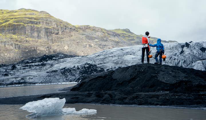 Travelers stand on the ice at Solheimajokull.
