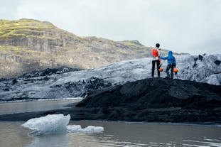Travelers stand on the ice at Solheimajokull.
