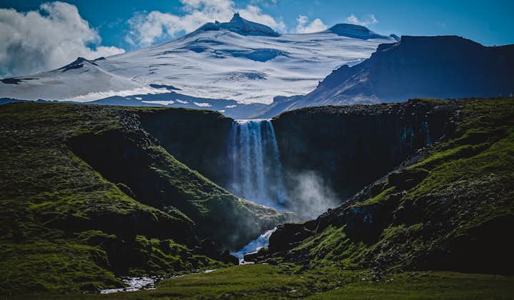 Snaefellsjokull stands behind a waterfall.
