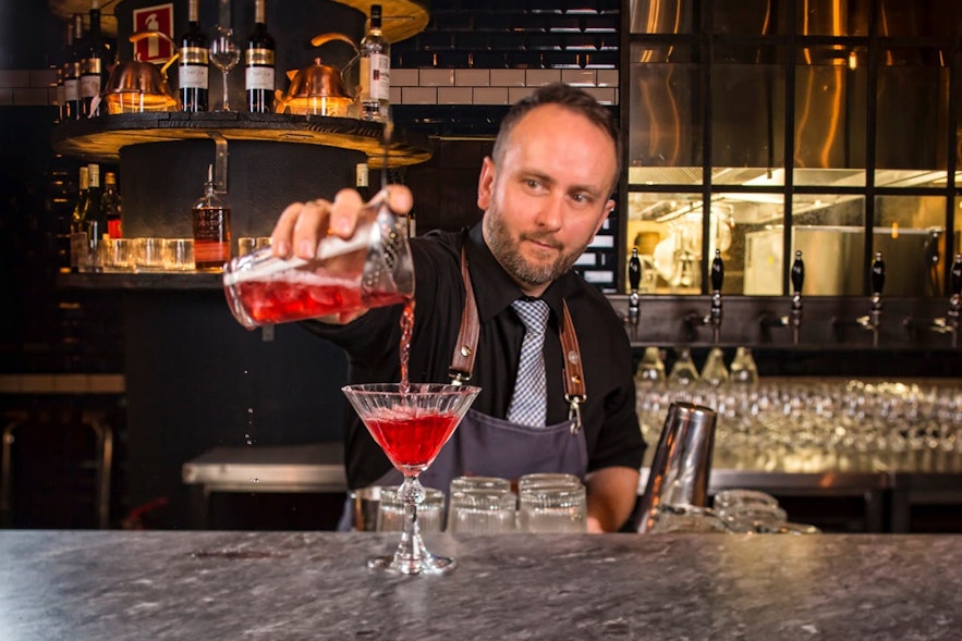 Un préparateur de cocktails sert une boisson en Islande.