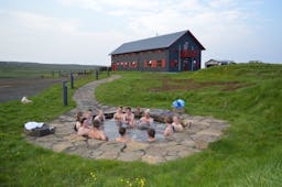 A Laugarfell hot spring filled with guests enjoying its waters. 